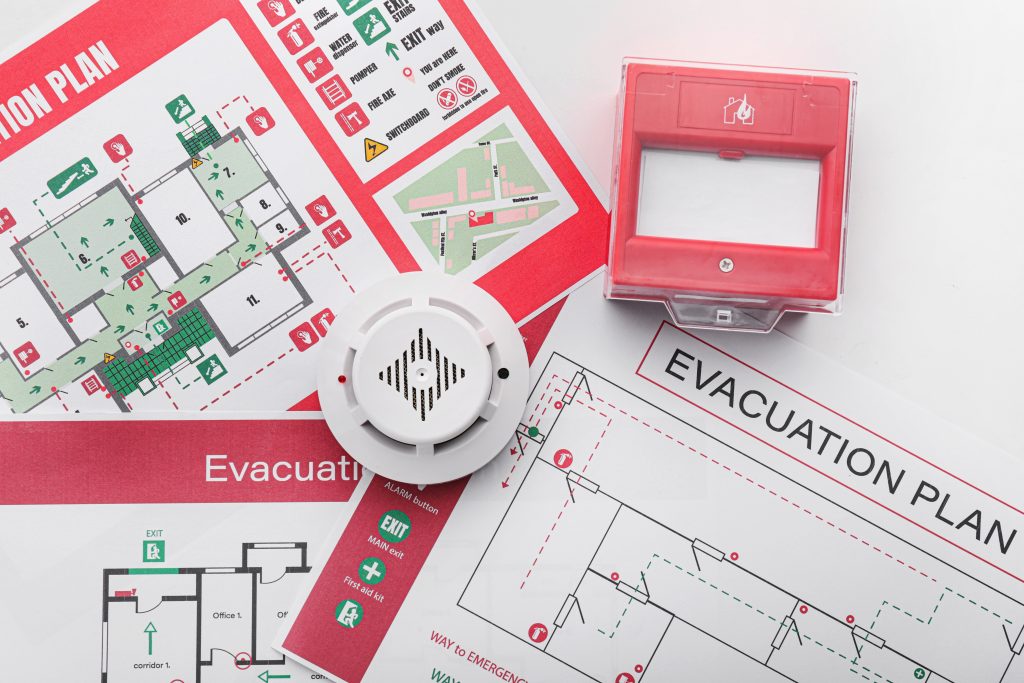 Evacuation plans, smoke detector and manual call point on white background Contact Us